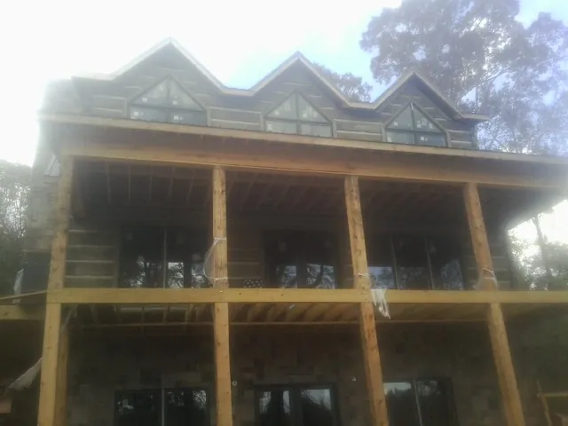 Dormers and porch framing on a large log home under construction — Roof Coating work by our crew in East Springfield