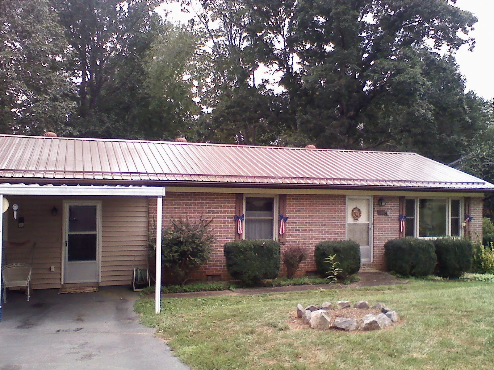 Bronze metal roof and carport on a brick ranch home — Roof Repair work by our crew in East Springfield